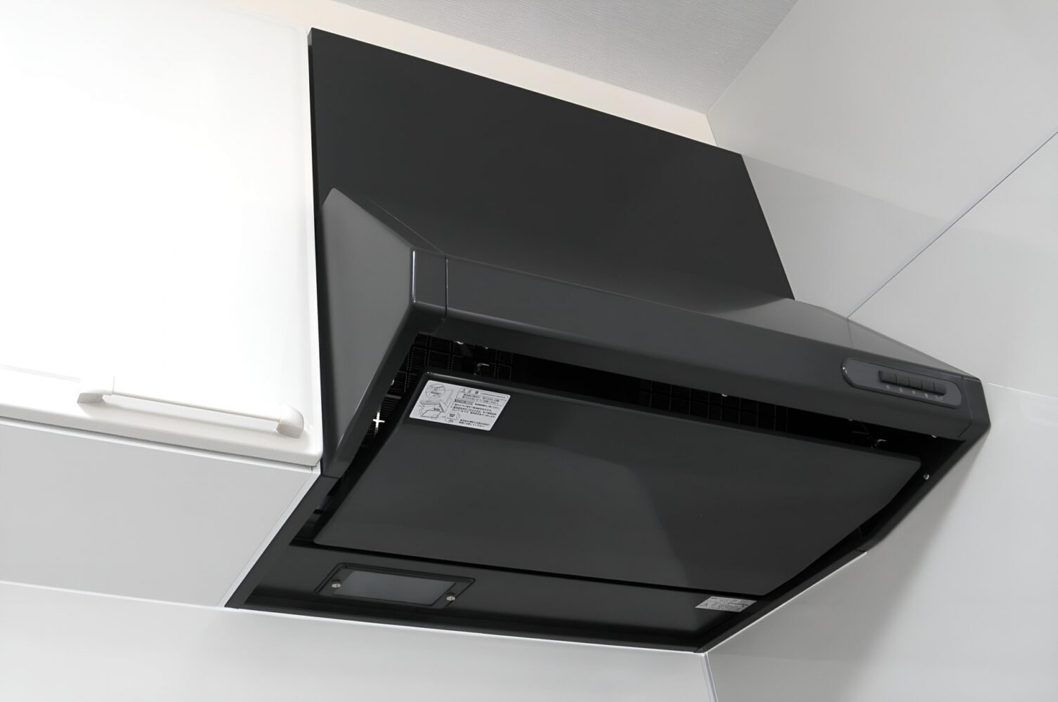 清掃が完了し、ピカピカに磨き上げられた黒のレンジフード(換気扇)。