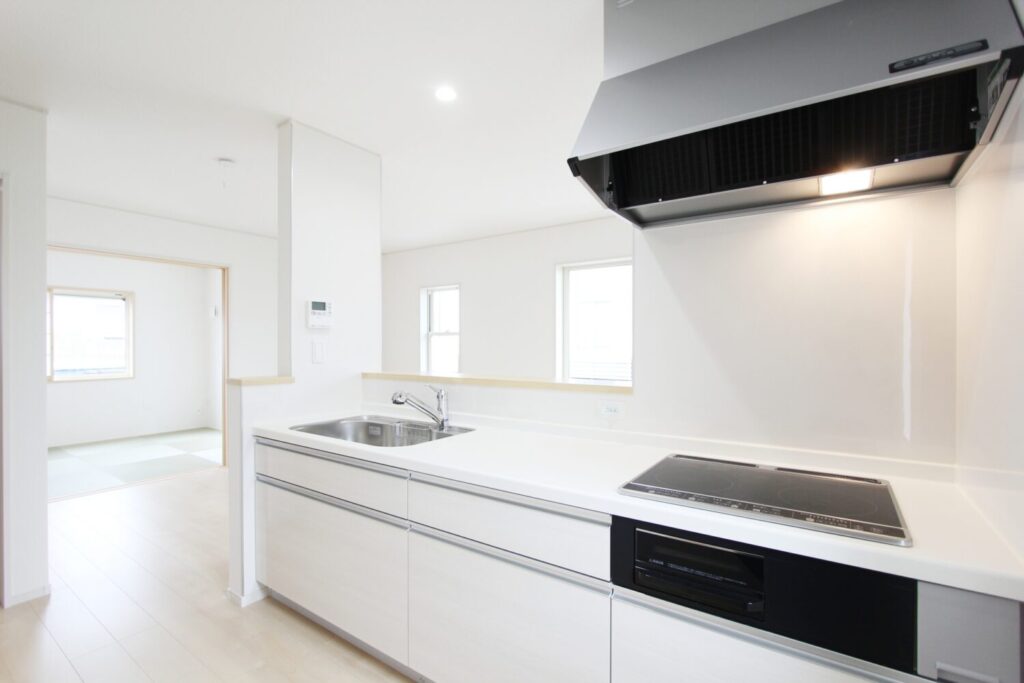 ハウスクリーニング後の、清潔感あふれる明るいシステムキッチン全体。